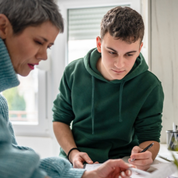 Mutter und Sohn arbeiten mit einem Blatt Papier