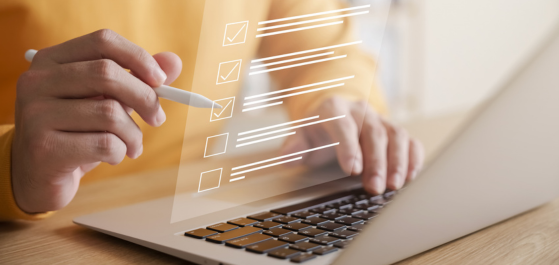 Person die vor einem Laptop sitzt und eine virtuelle Checkliste abhakt 