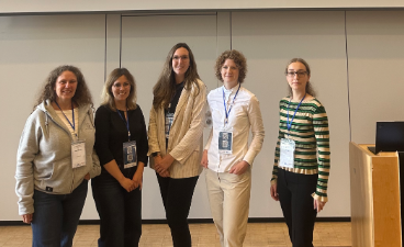 Fünf Frauen stehen nebeneinander rechts ist ein Rednerpult 